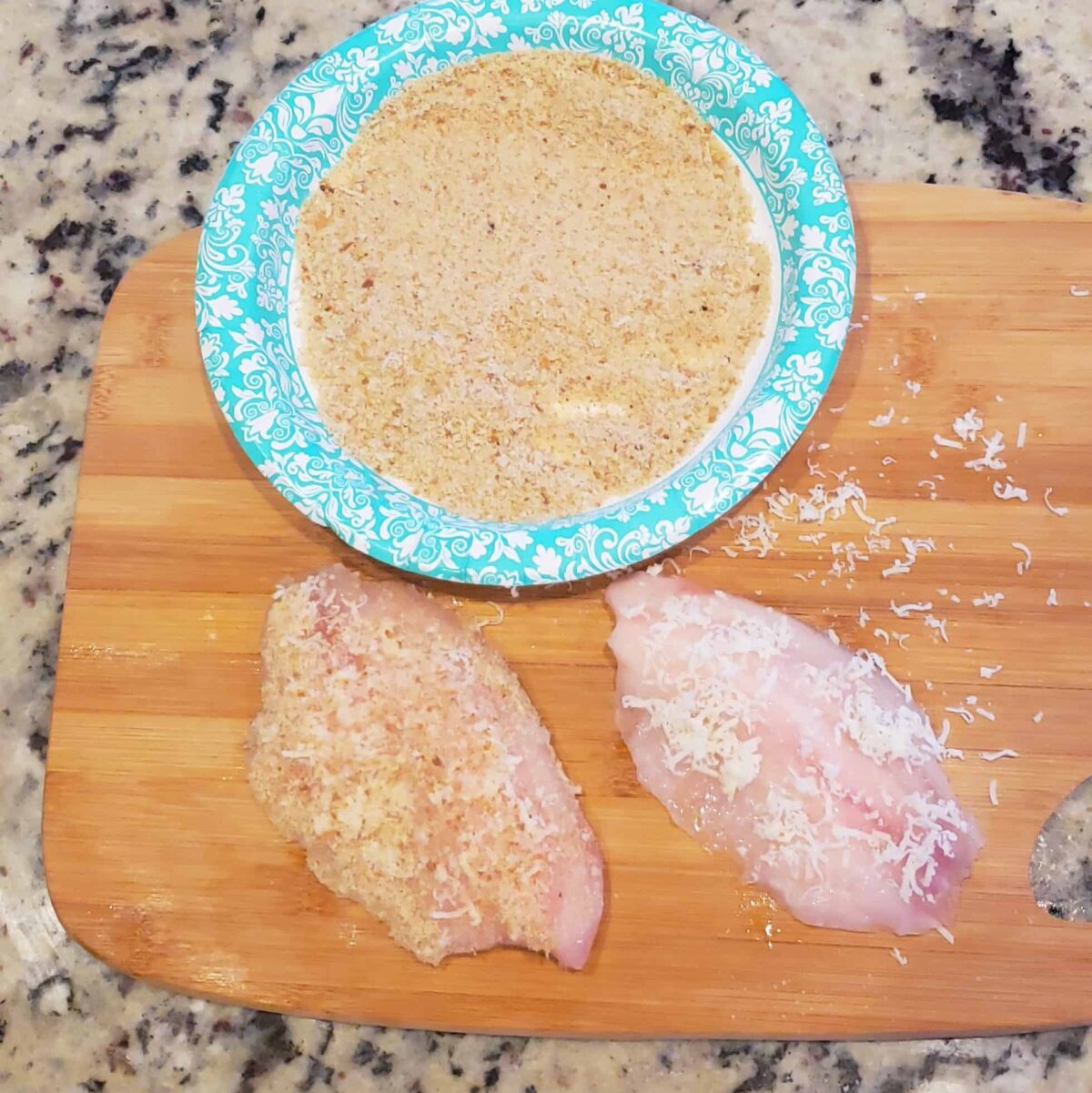 frozen tilapia fillets on wooden cutting board breadcrumbs in plate