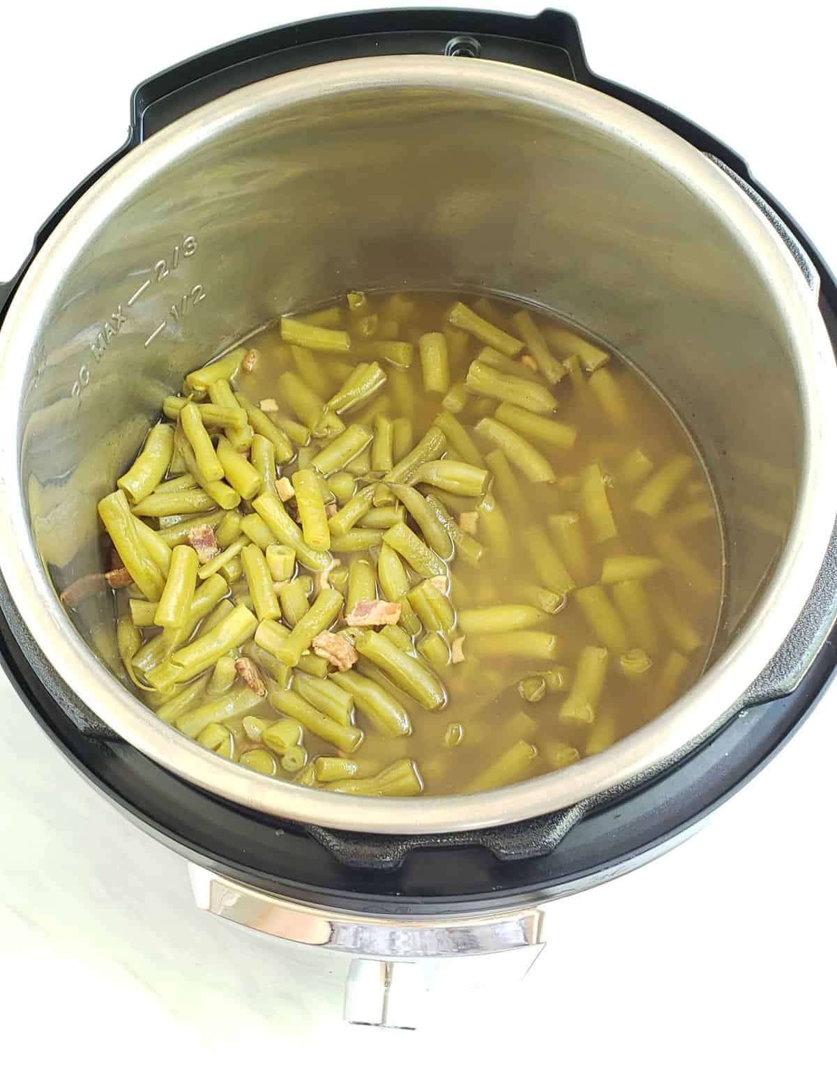 Cooked green beans and bacon over head view in an Instant Pot