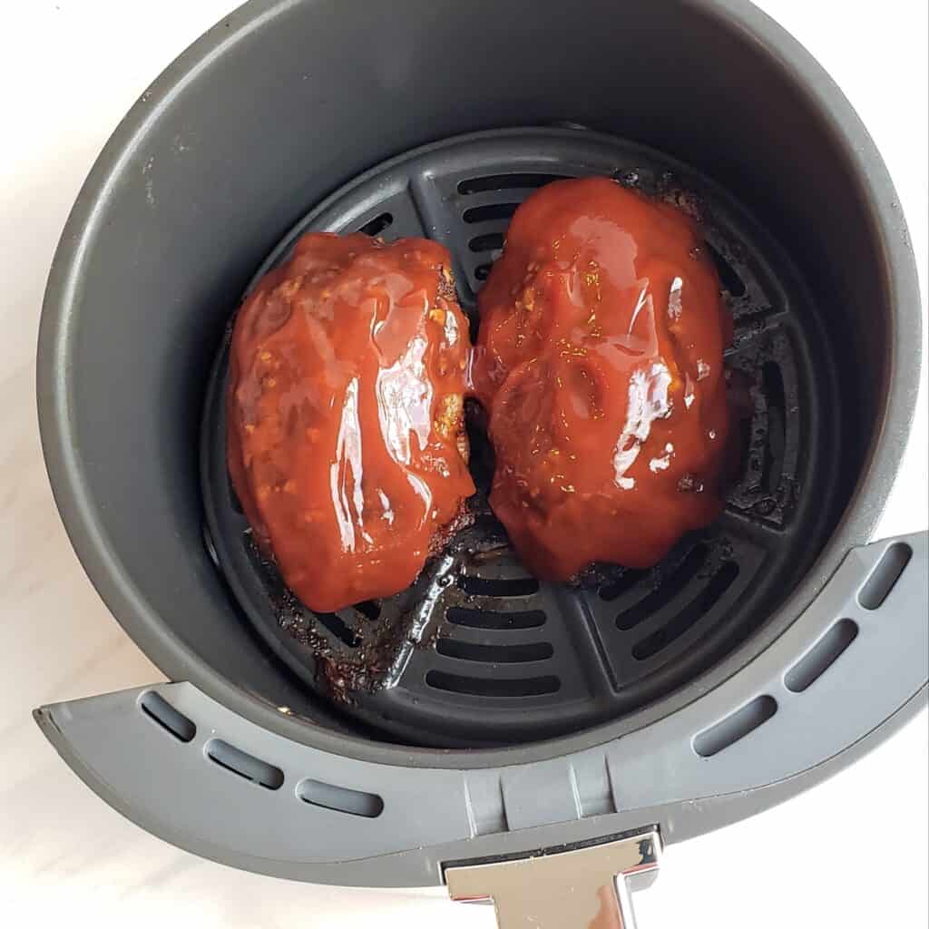 Topping Best Air Fryer Meat Loaf with Tangy Sauce  in the air fryer