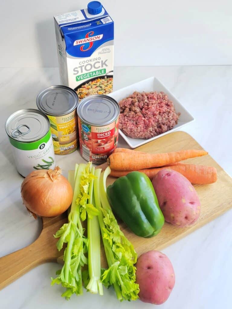 Ingredients for hamburger vegetable soup: canned corn, tomatoes, green beans, onion celery, ground beef , potato
