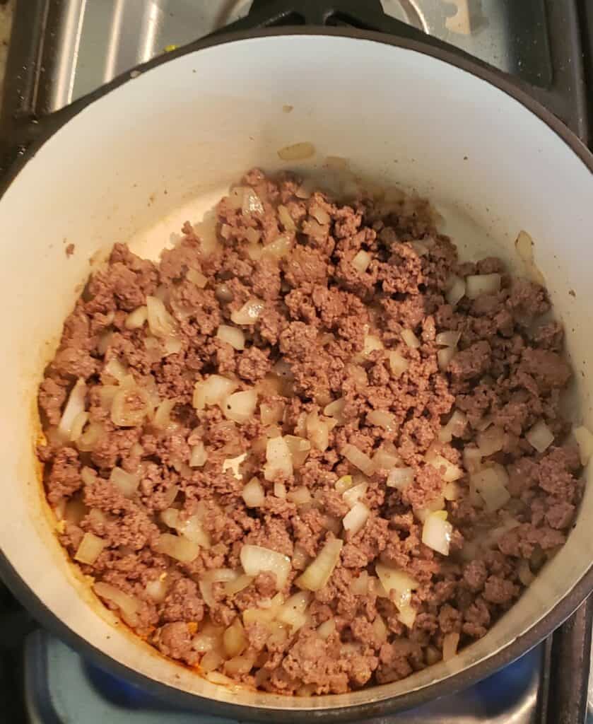 Ground beef and onion in enamel coated pot