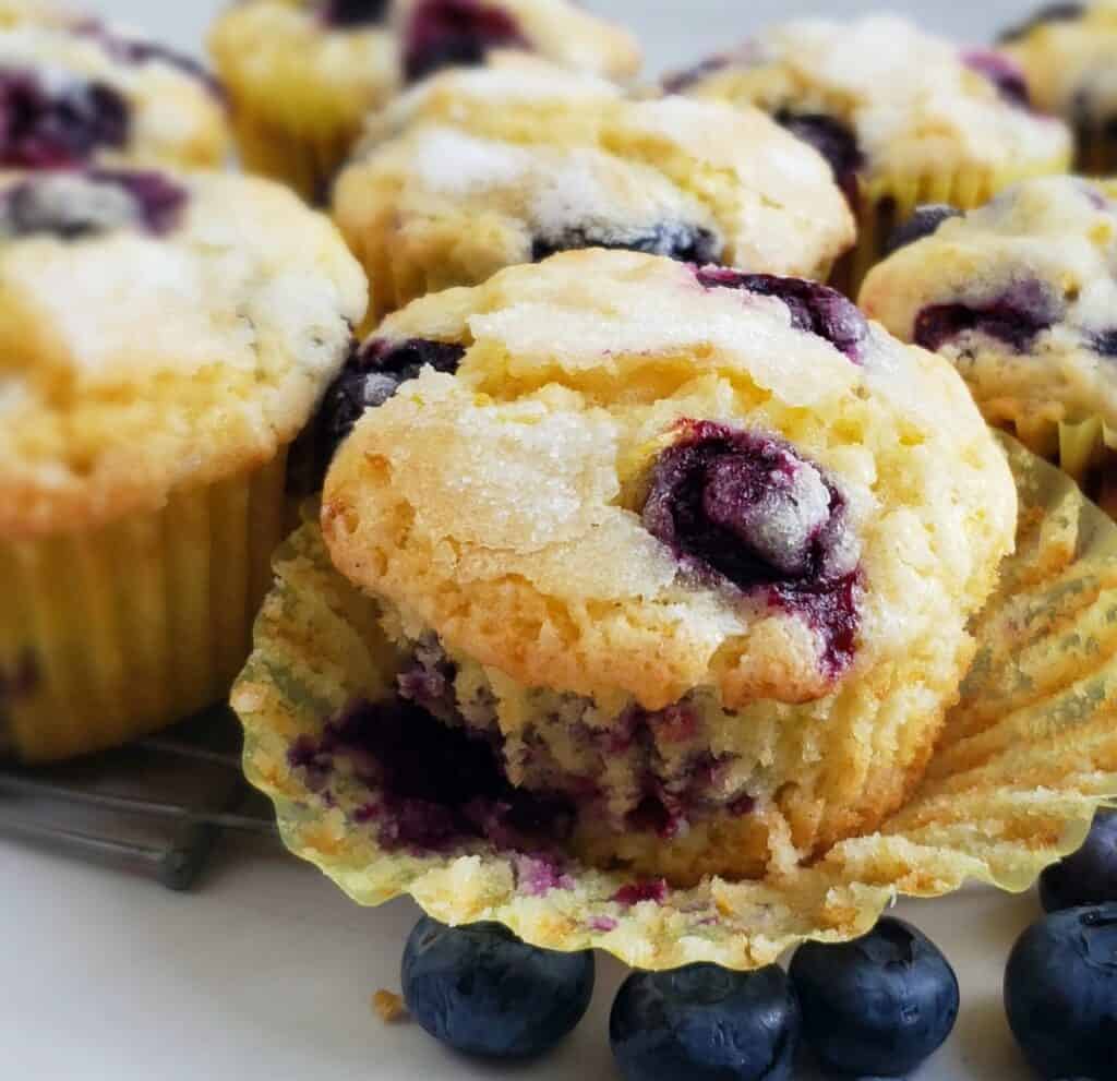 close up blueberry muffin with paper liner peeled back
