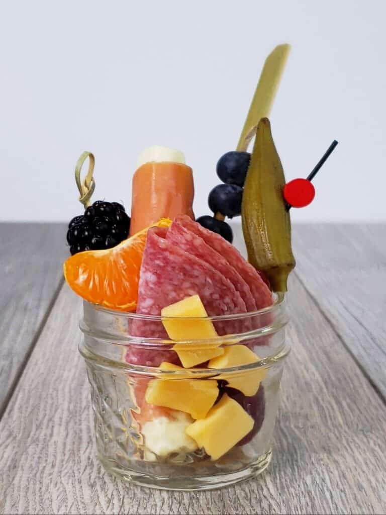 Small Mason jar filled with charcuterie snacks