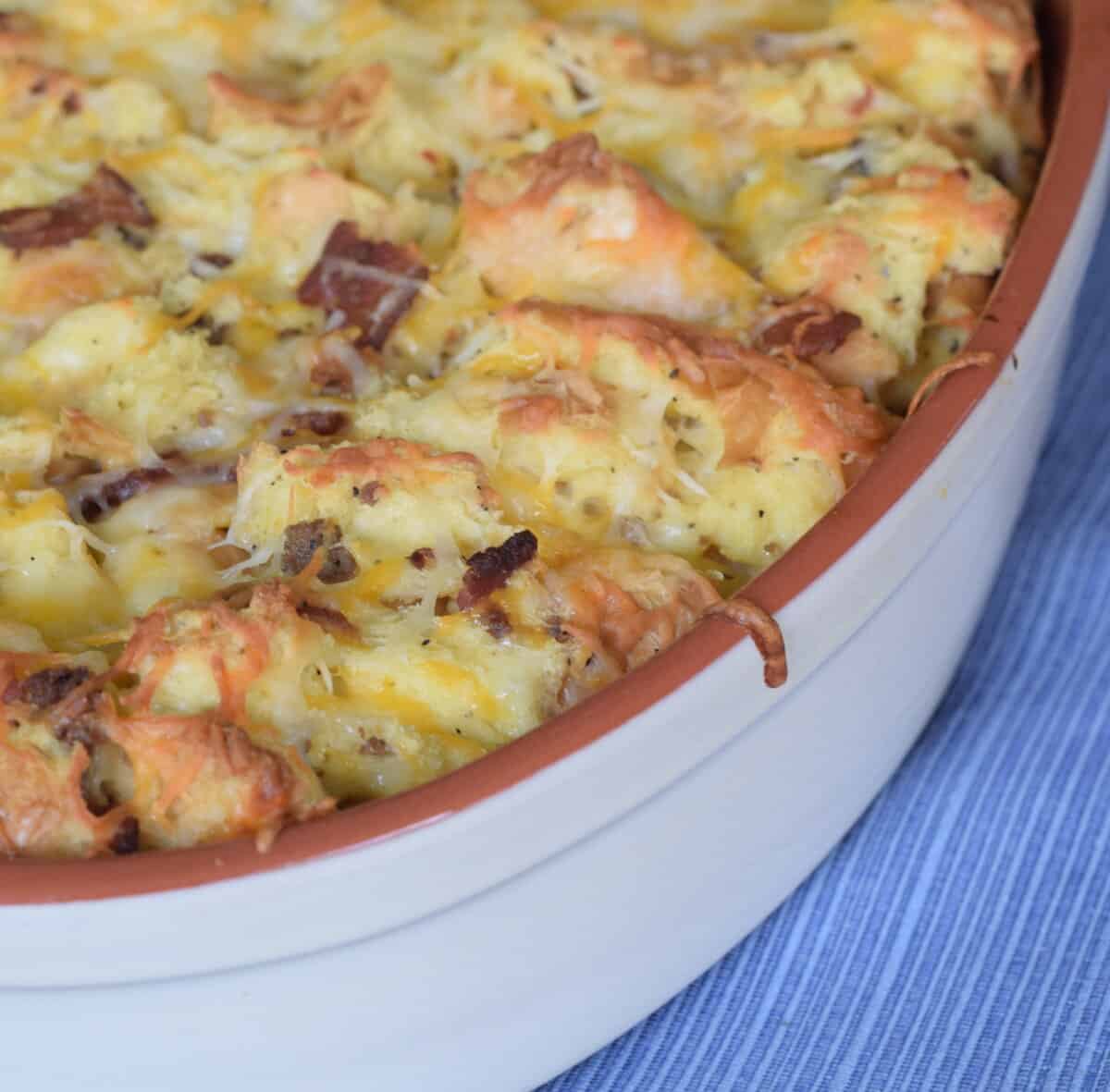 Bacon sausage strata in white casserole dish close up.