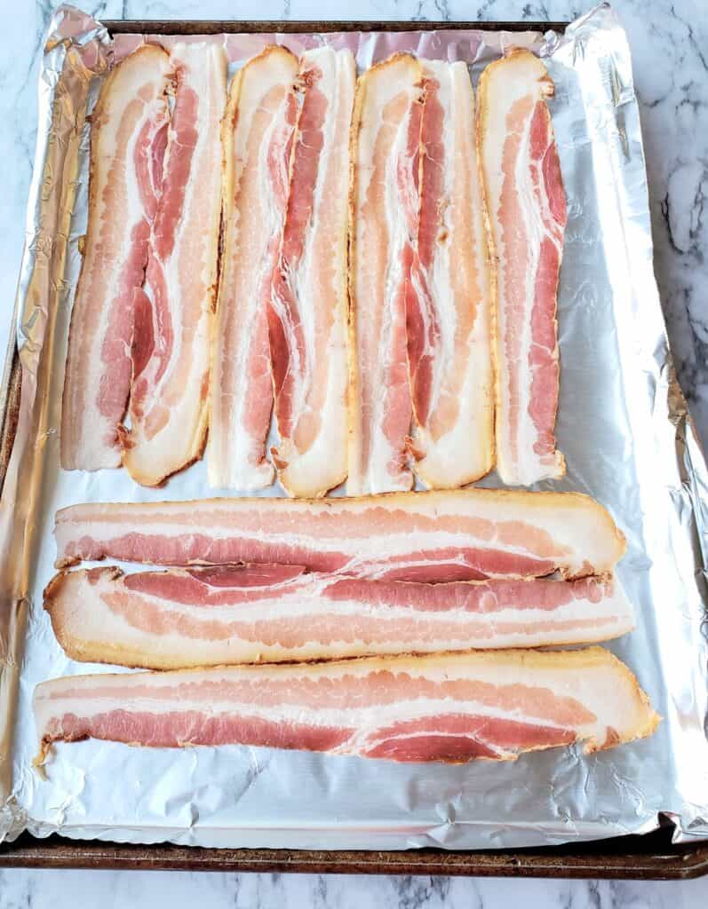 Thick cut bacon on a foiled line sheet pan