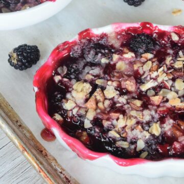 Close up of mini blackberry cobbler with juices spilling over the side