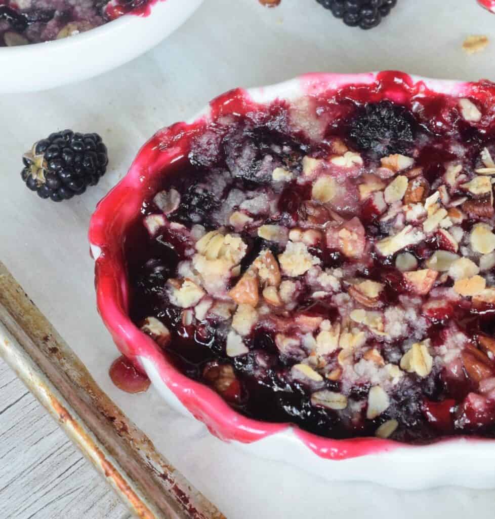 Close up of mini blackberry cobbler with juices spilling over the side