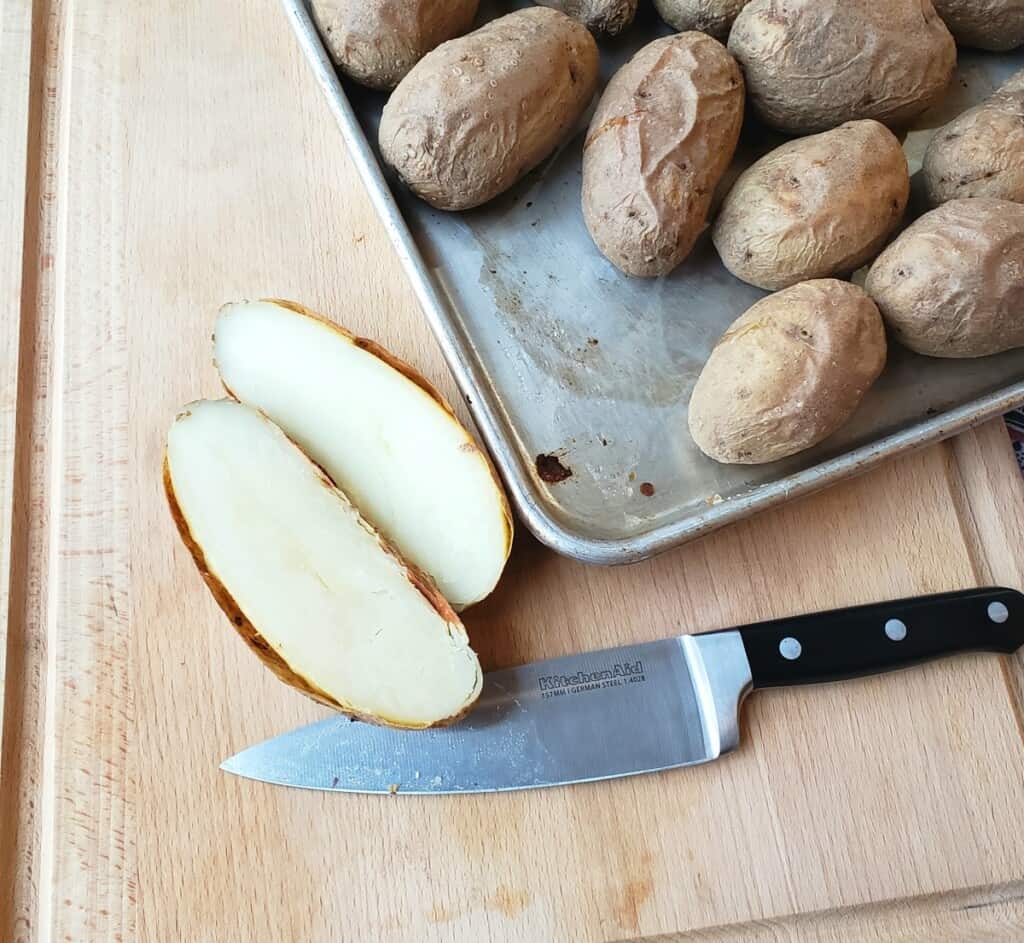 Process shot: sliced baked potato on baking sheet