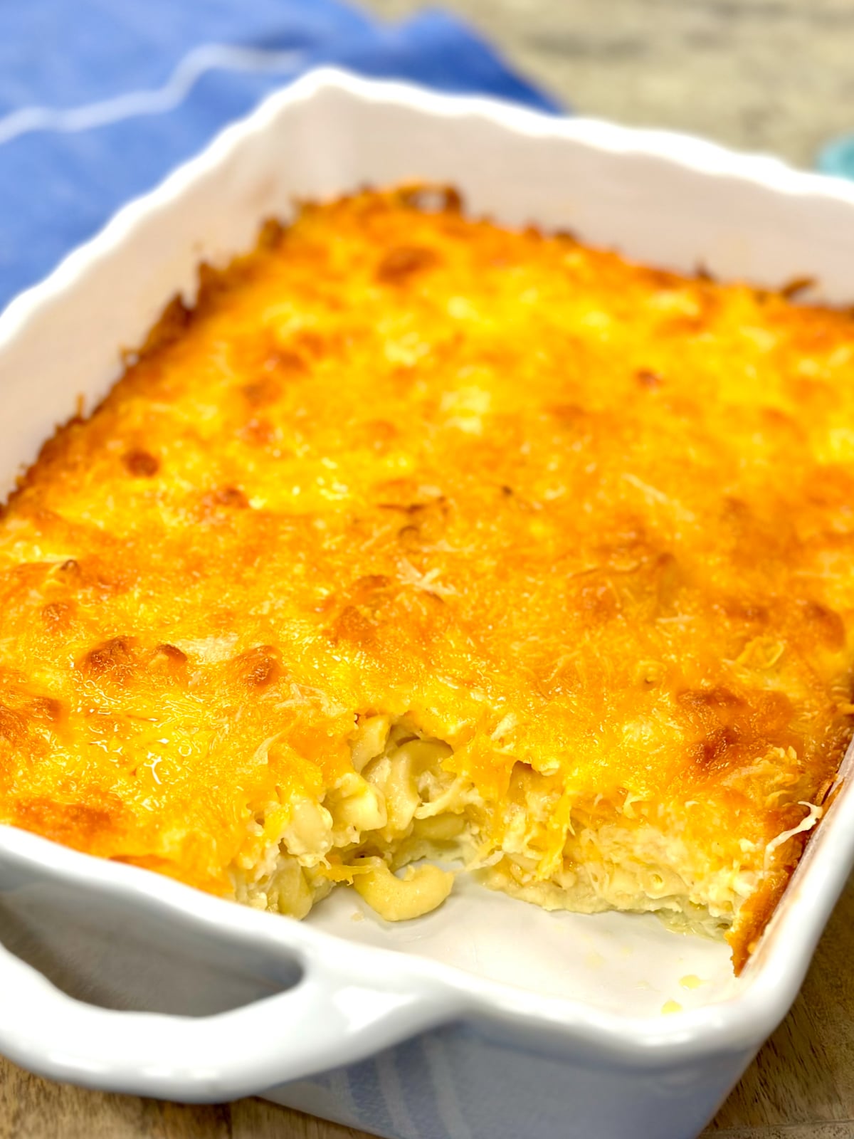 Macaroni and Cheese in a white casserole dish with serving scooped out.