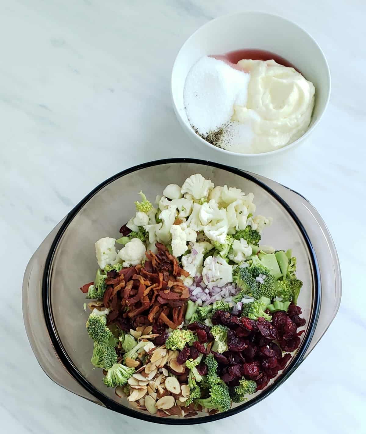 All salad ingredients for this recipe neatly separated in a bowl with dressing ingredients in a smaller bowl 