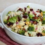 White bowl on pink cloth full of broccoli cauliflower mixture