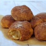 apple pie filled donuts with bite out on brown paper