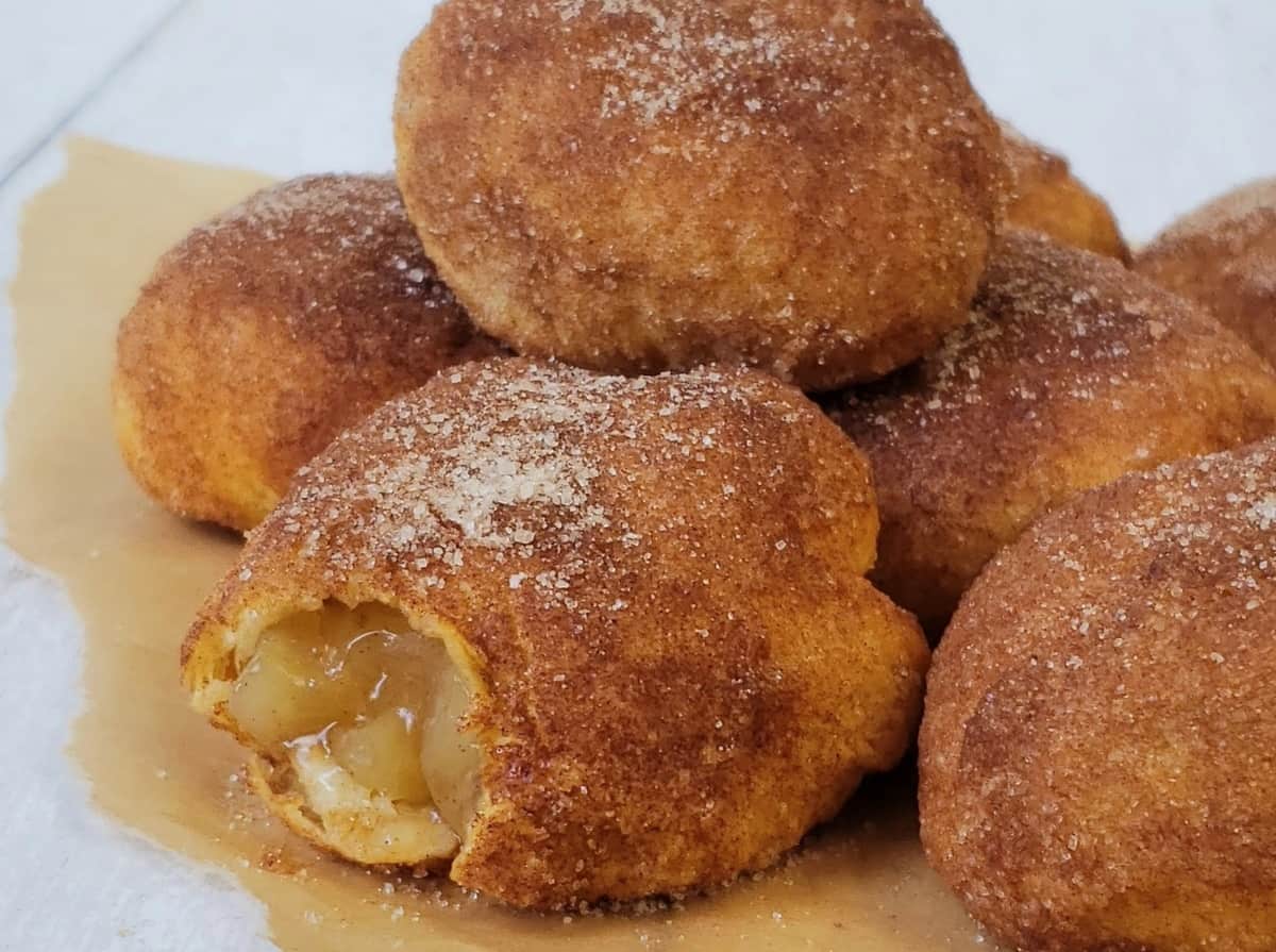 Apple pie filled "fried" dough with a bite out of one.