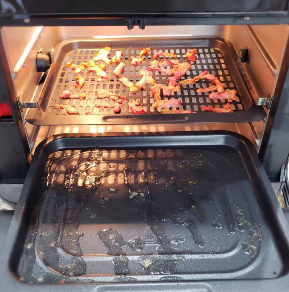 Cooked chopped bacon in an oven style air fryer.