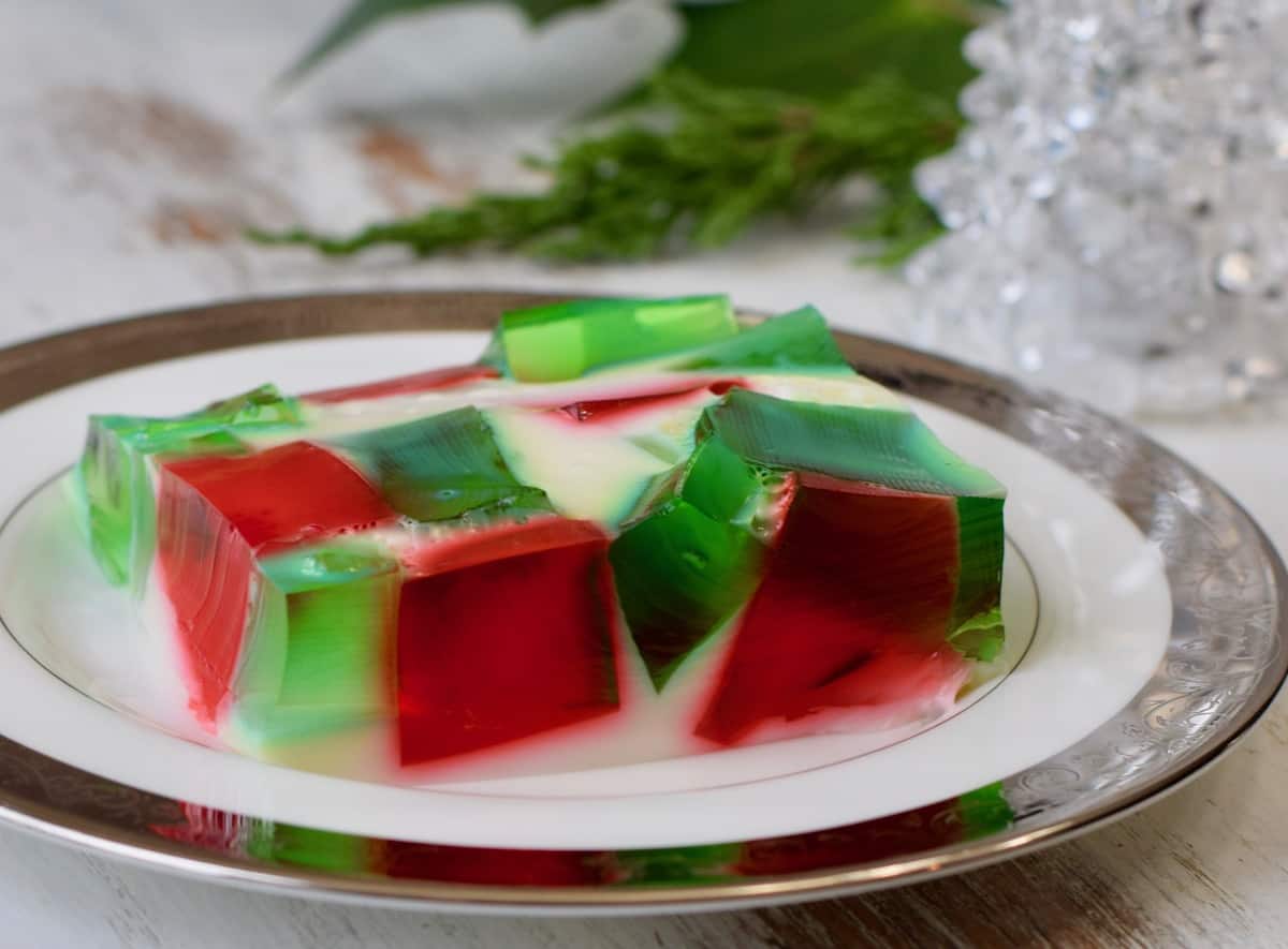 Red and green Jello cubes in Stained Glass Jello Salad with greenery in background.