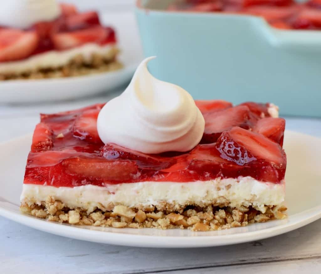 Strawberry Pretzel Salad square with dollop of Cool Whip.