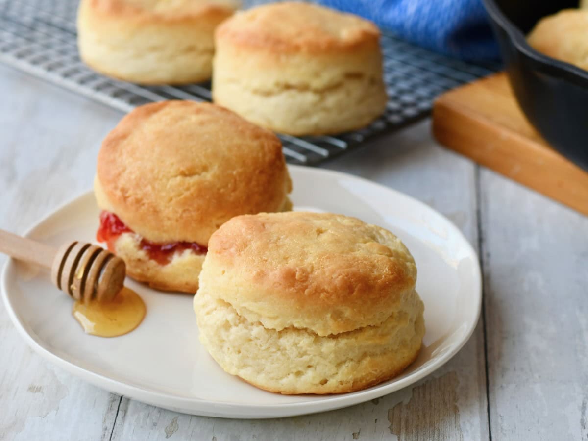 Two ingredient biscuits on white plate with one filled with jam.