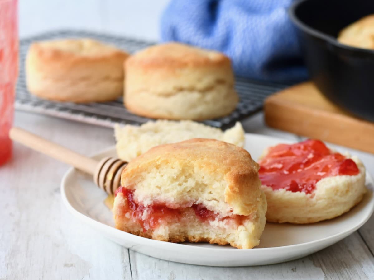 Homemade biscuit and strawberry jam with bites taken out.

