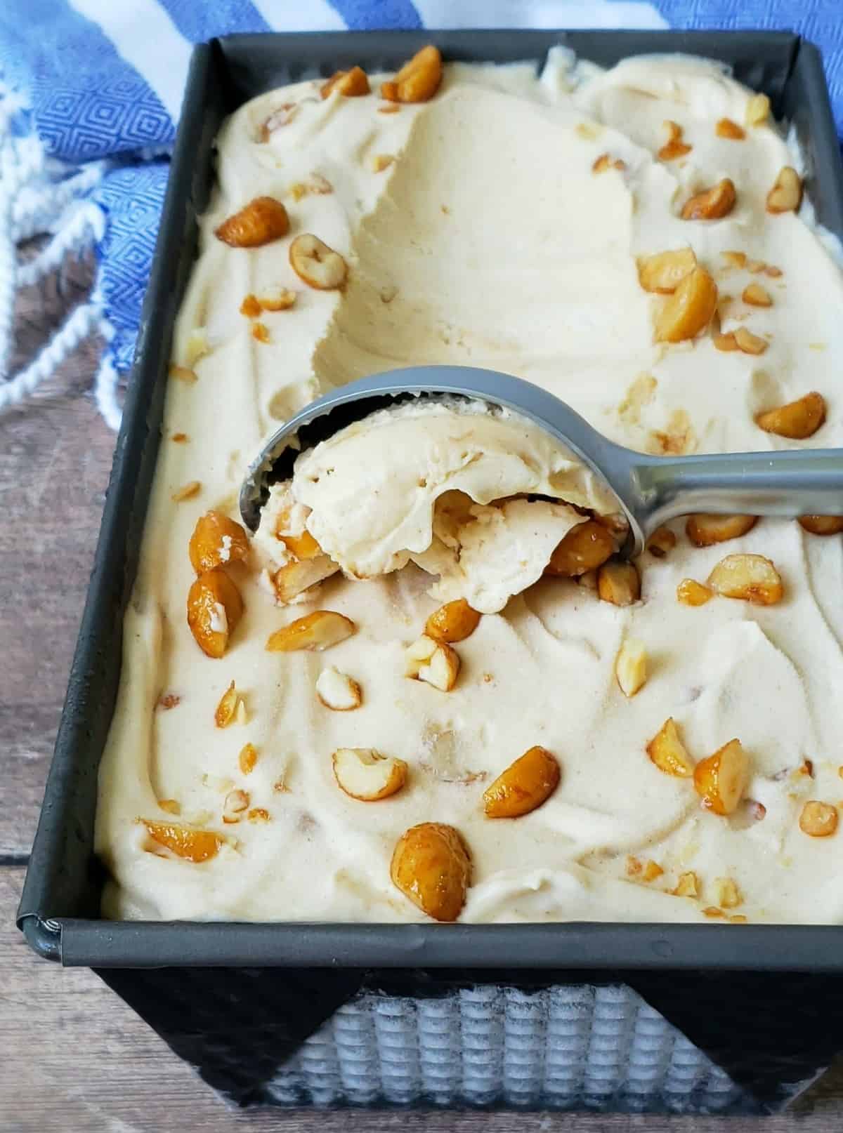 No churn Peanut Butter Ice Cream in loaf pan scooping with ice cream scoop.