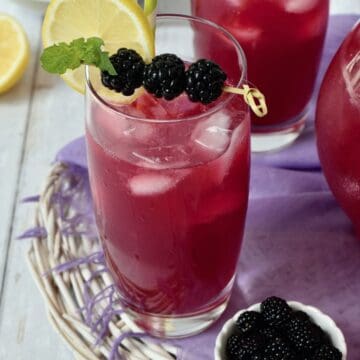 Glass of blackberry lemonade with fresh blackberry garnish.