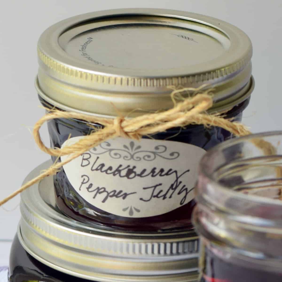 Blackberry Pepper Jelly close up of tiny jar labeled with jute string tied.