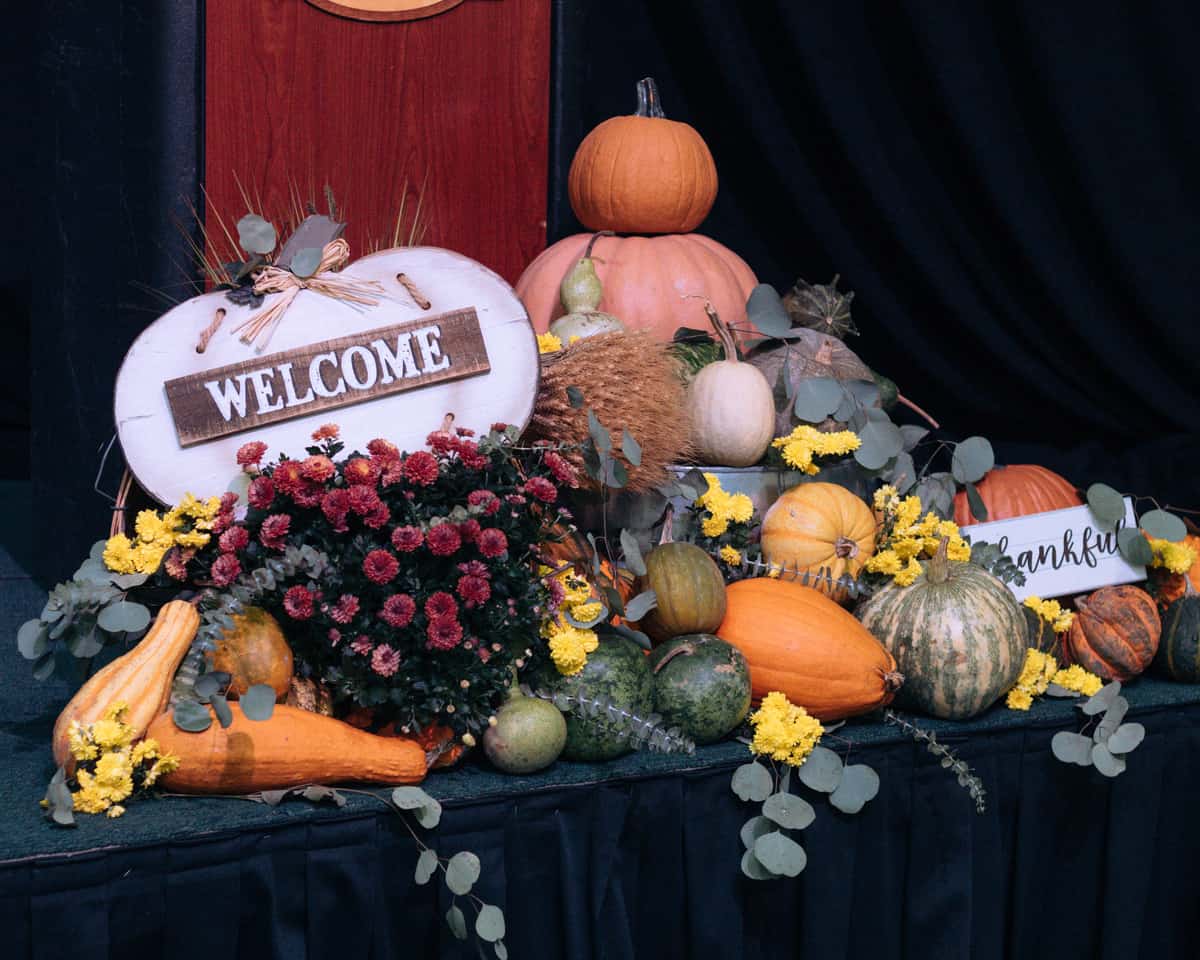 Welcome sign among gourds and fall decor.