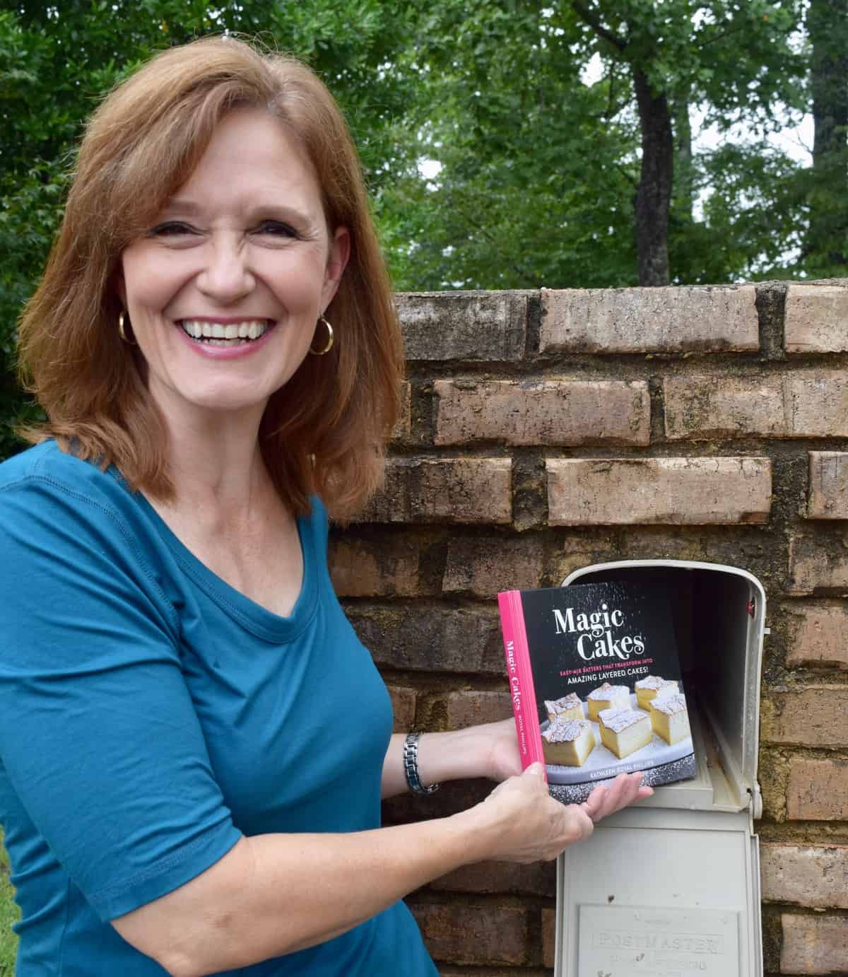 Woman in blue shirt getting a cookbook out of mailbox.