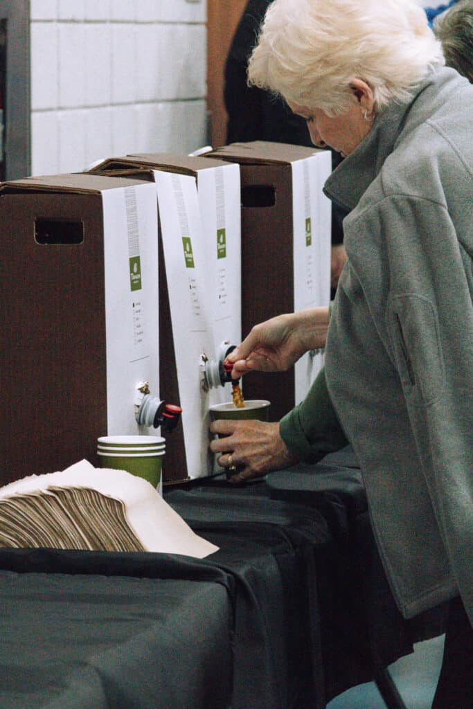 Woman pouring coffee from portable Panera karafe.