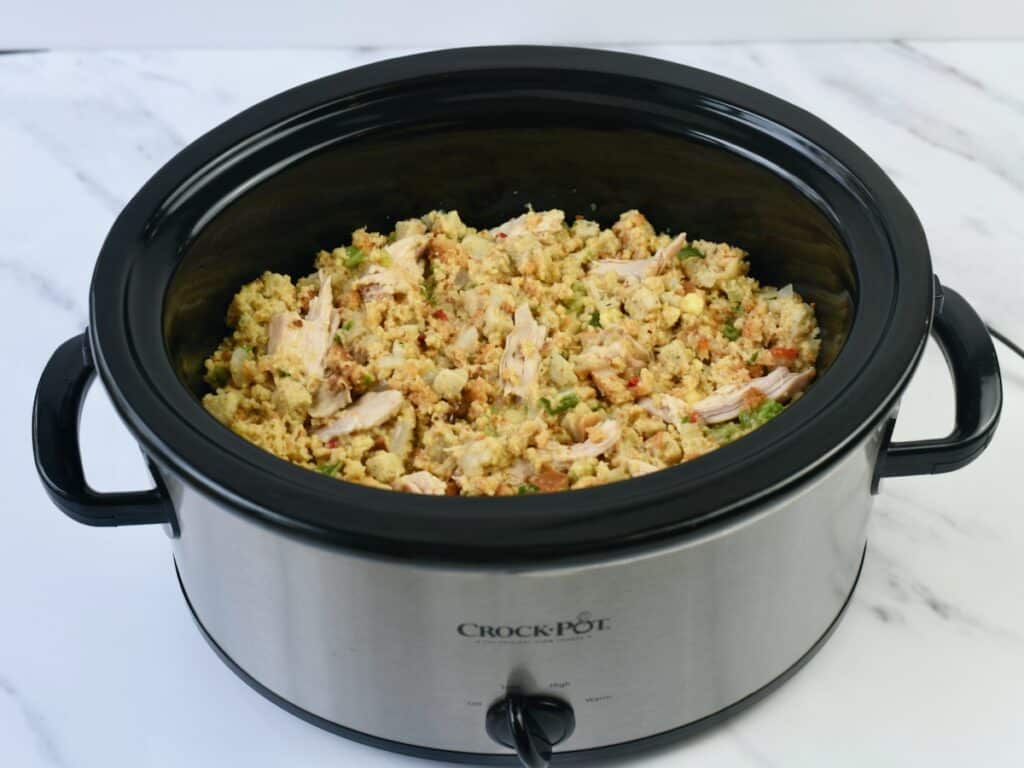 Chicken and cornbread dressing in Crockpot before cooking with lid off.
