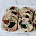 Rectangle white plate of red and green oreo shortbread cookies.