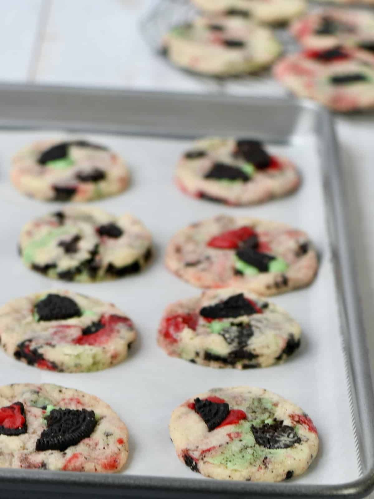 Red and Green cookies and cream shortbread cookies baked on a parchment lined baking pan.