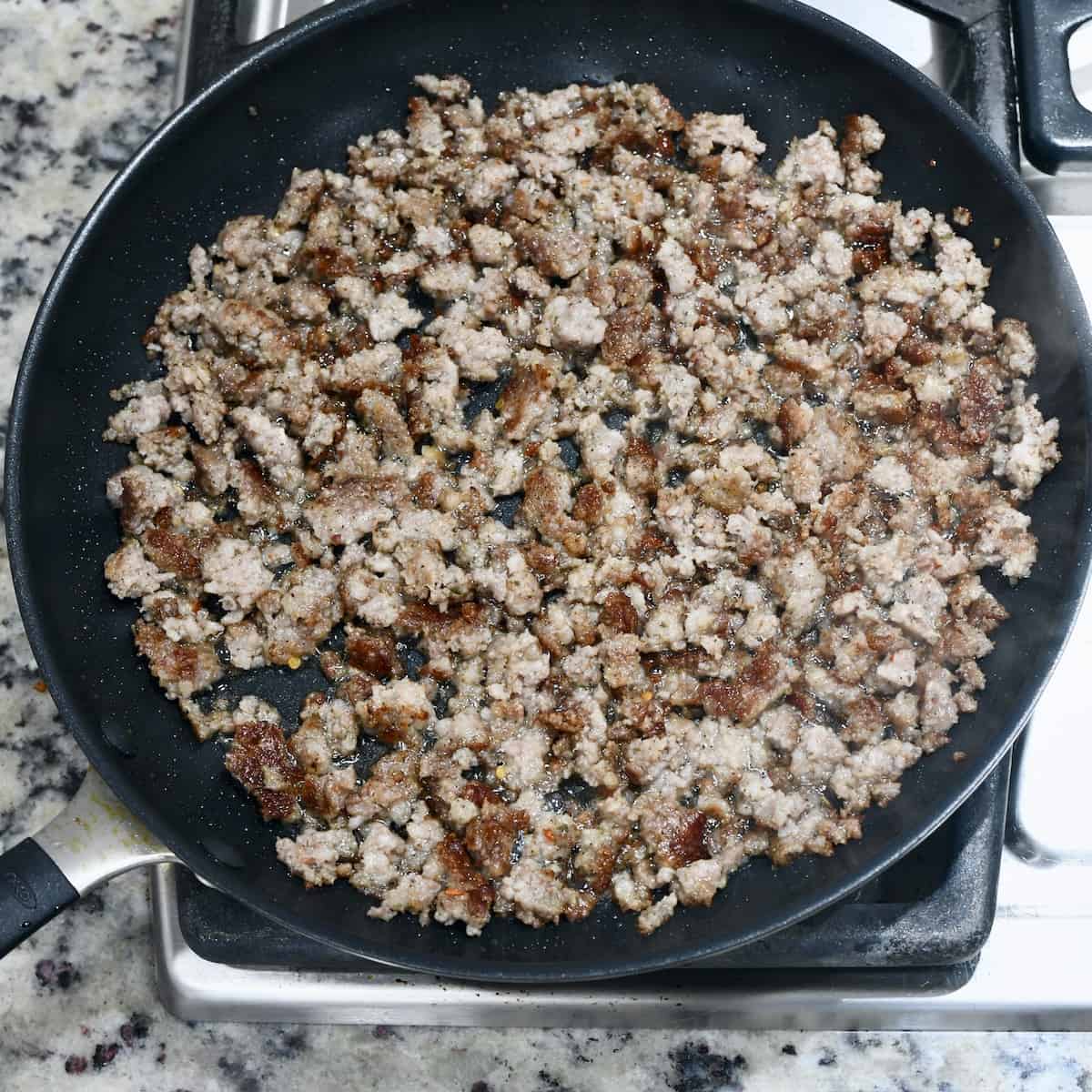 Browning ground sausage in a skillet.