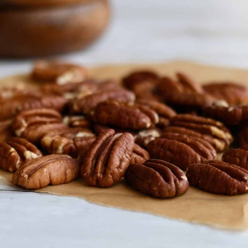 Pecan halves on brown parchment paper.