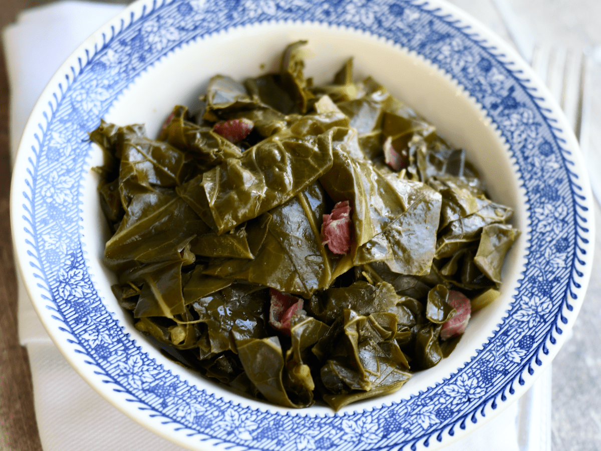 Blue rimmed bowl filled with cooked collard greens