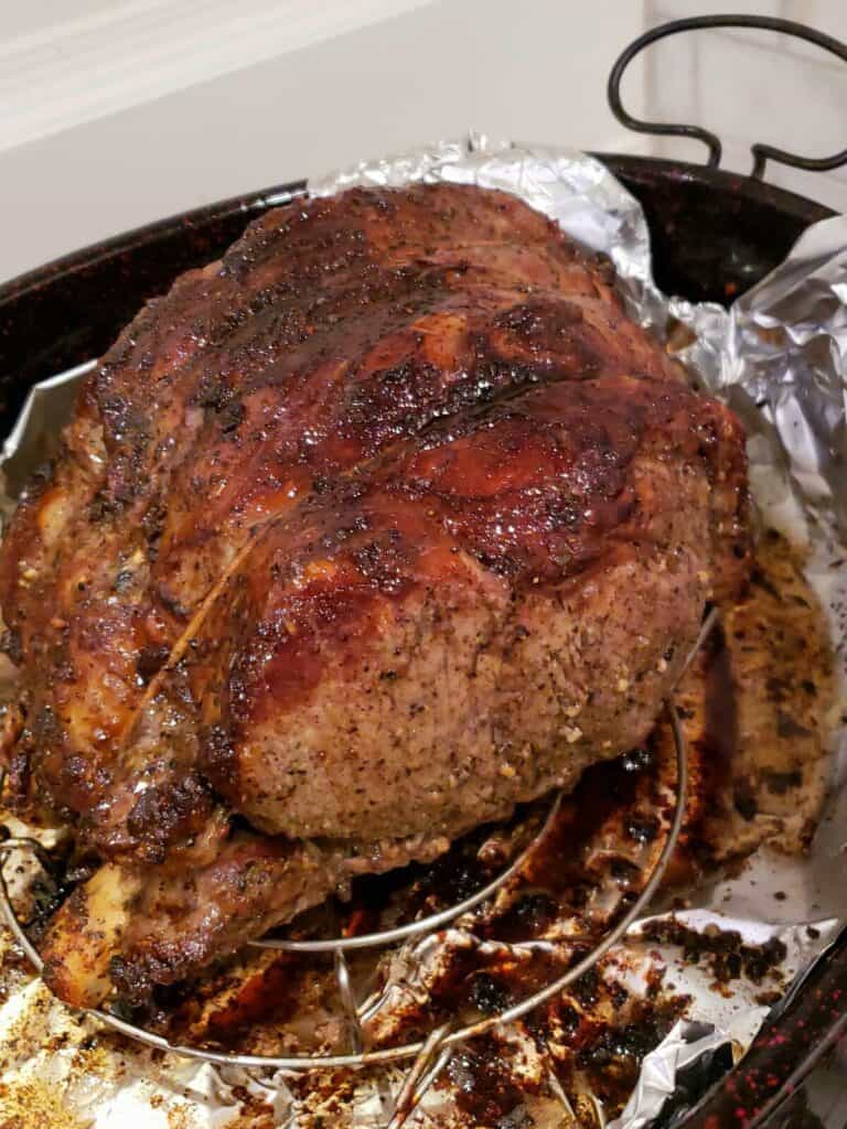 Beef rib roast baked on a rack in a baking pan with drippings in the bottom
.
