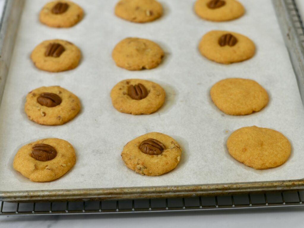 Baked cheese pecan wafers on baking sheet.
