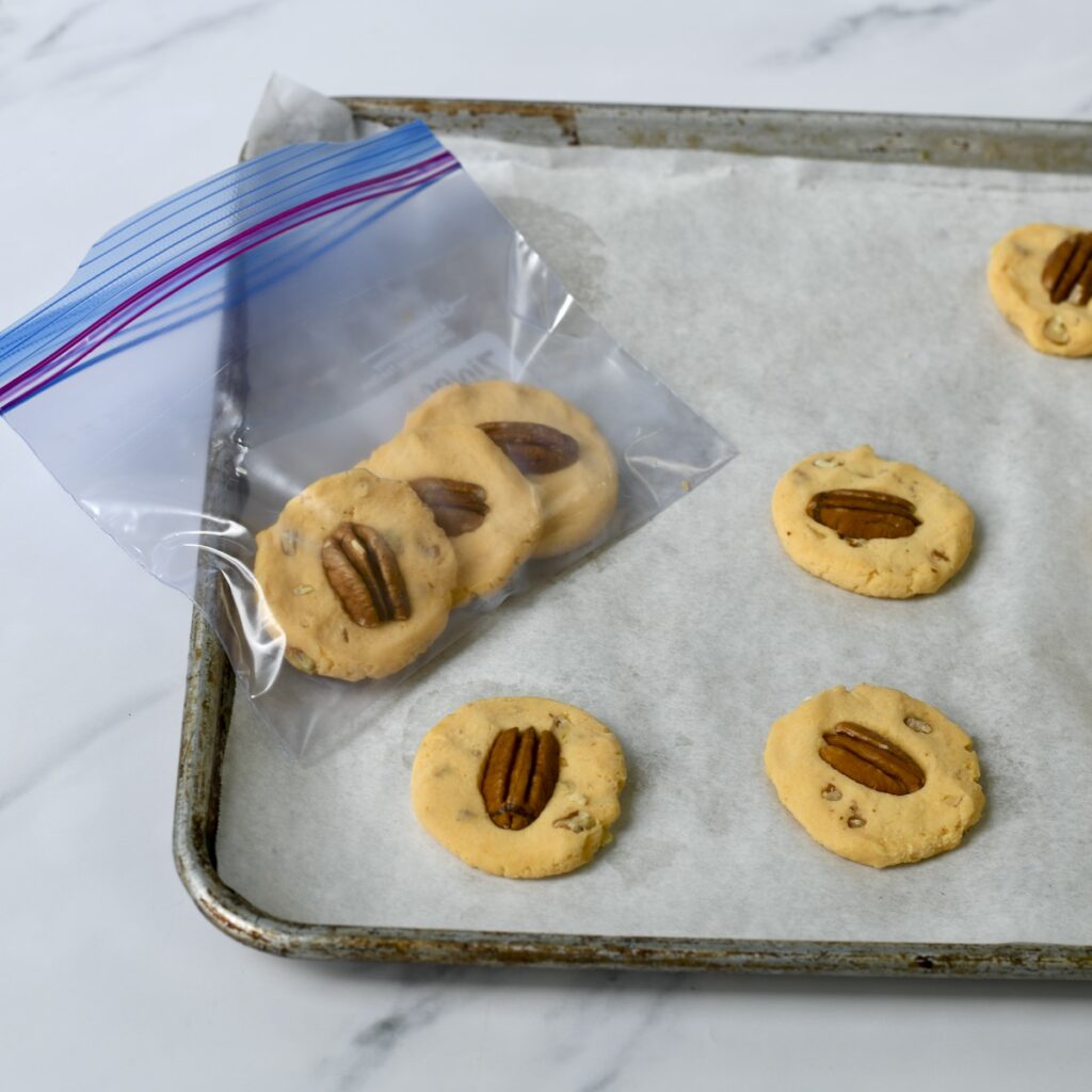 Frozen unbaked pecan cheese wafers placed in freezer bag for storage.