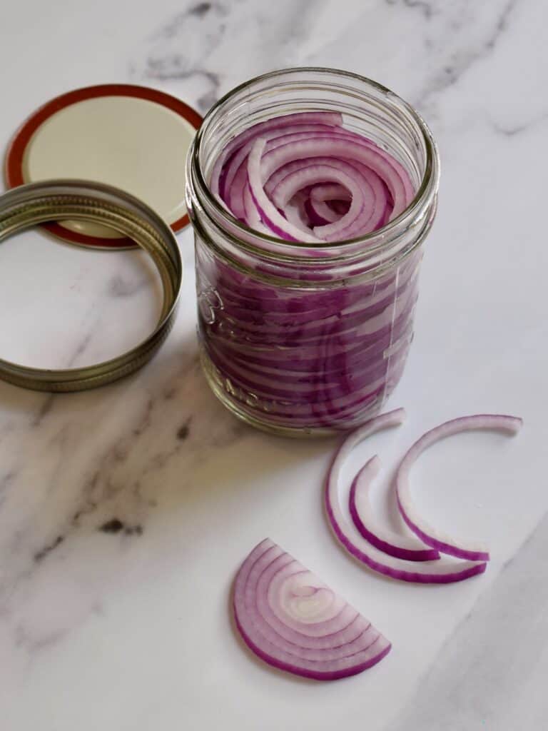 sliced red onions in a Kilner jar
