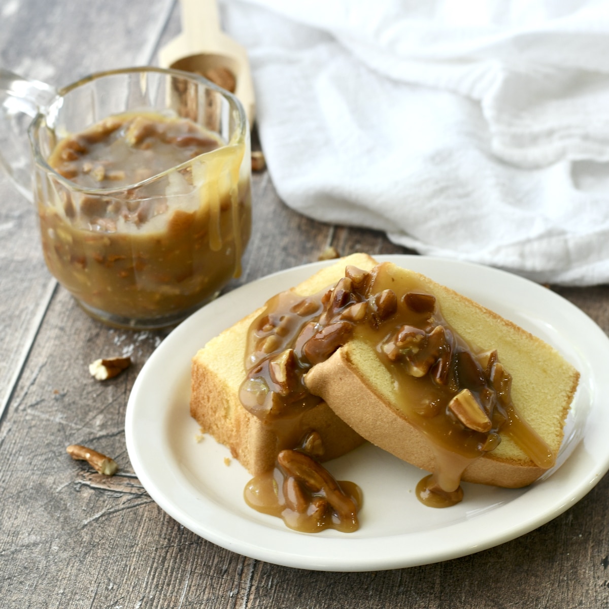 Easy Pecan Praline Sauce as topping on two pieces of pound cake.