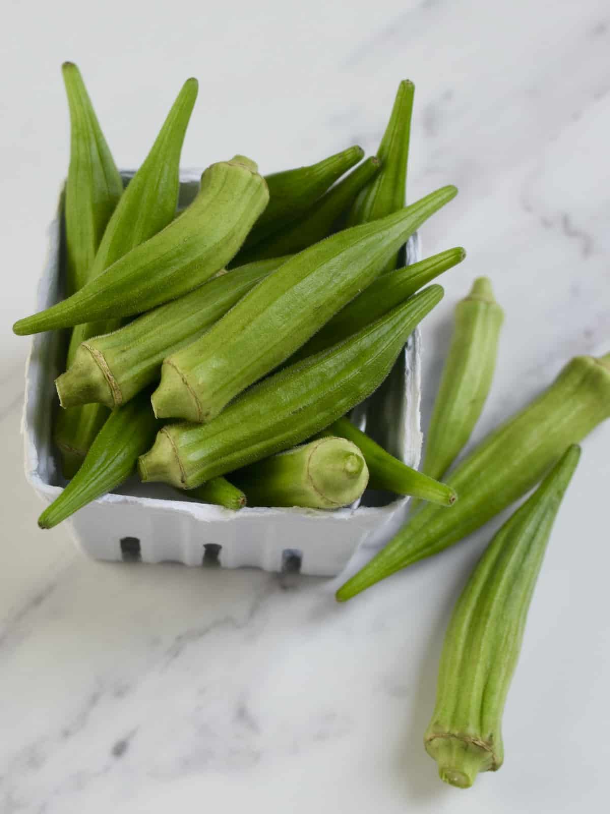 Top down image of a box of whole okra.