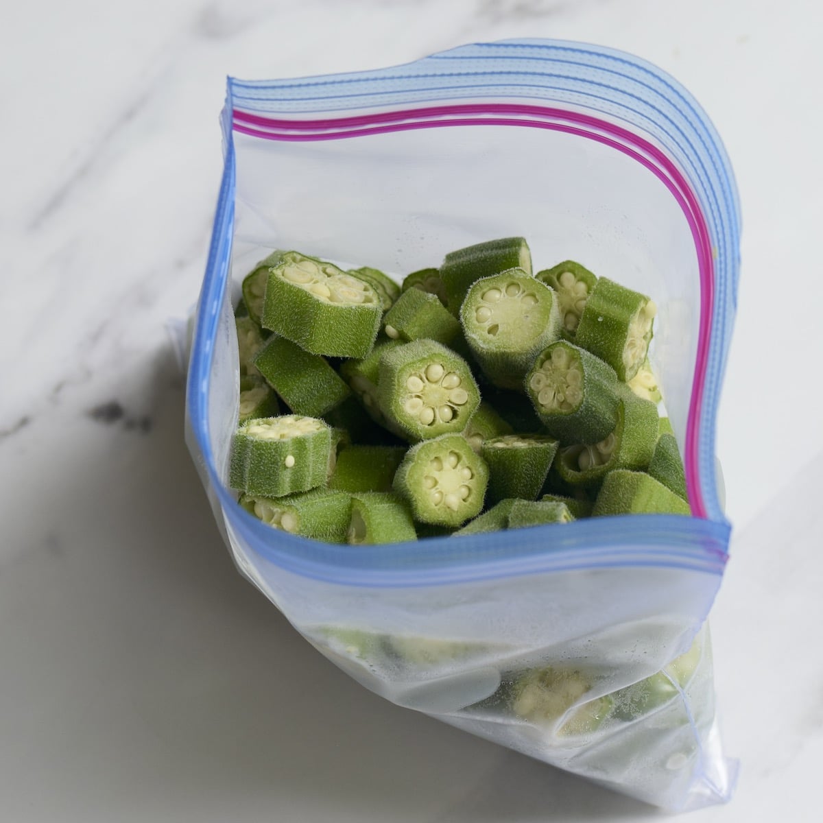 A Ziploc freezer bag filled with sliced okra.