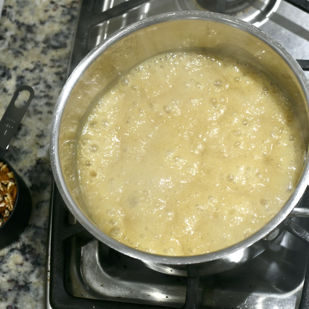 Praline sauce mixture boiling in a saucepan.