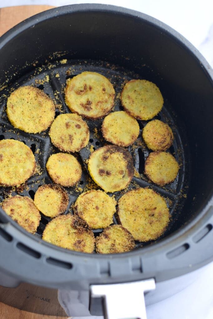 Fried air fryer squash in air fryer basket.