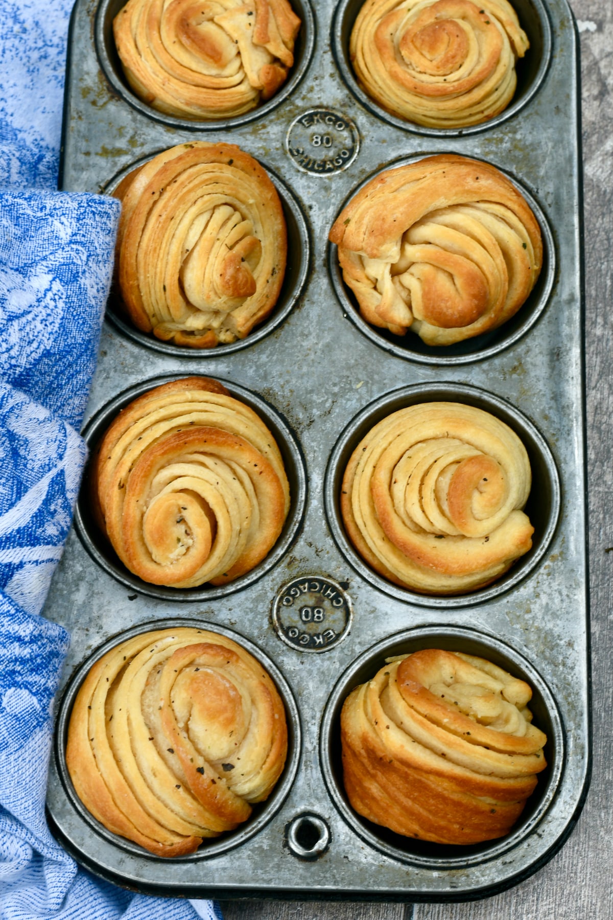 Garlic butter cruffins in metal muffin pan.