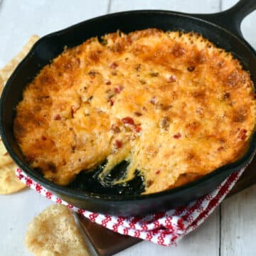 Featured image of baked pimento cheese dip with bacon in a cast iron skillet.