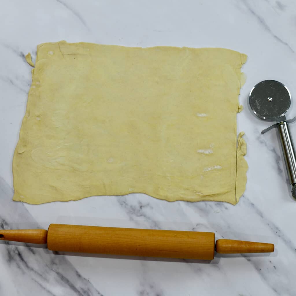 Using a rolling pin to roll out puff pastry.