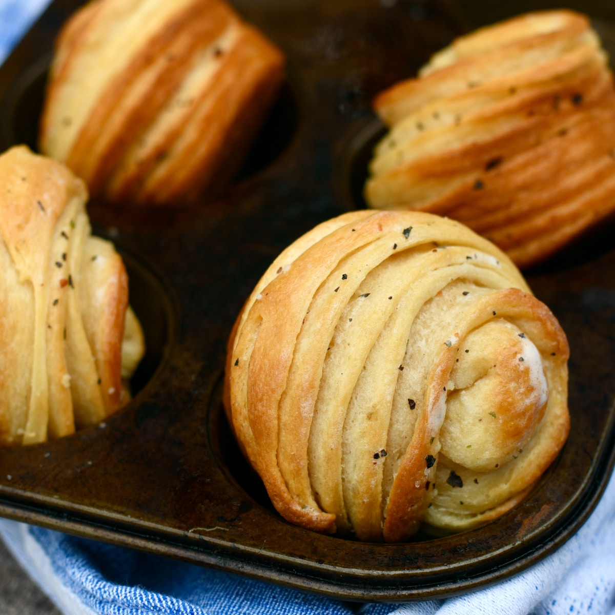 Close up garlic herb cruffins in muffin pans.