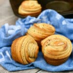 Three garlic butter cruffins on a blue cloth.