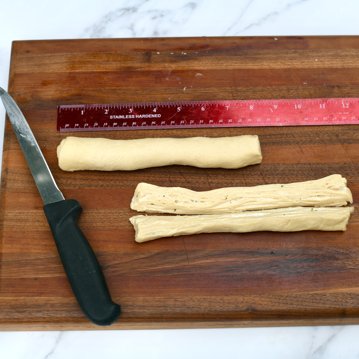 Savory cruffin dough rolled into 2 logs with one cut in half lengthwise.