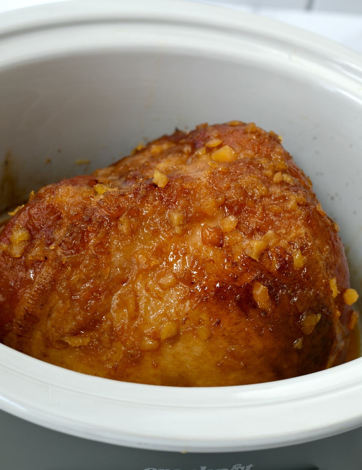 Horizontal shot of cooked pineapple brown sugar ham in the slow cooker.